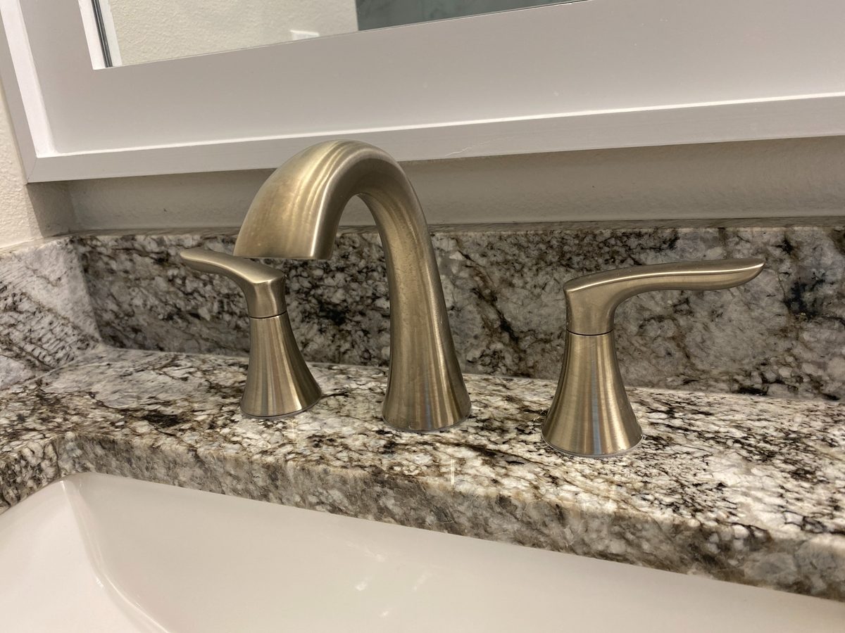 Brushed nickel bathroom faucet installed on a granite countertop