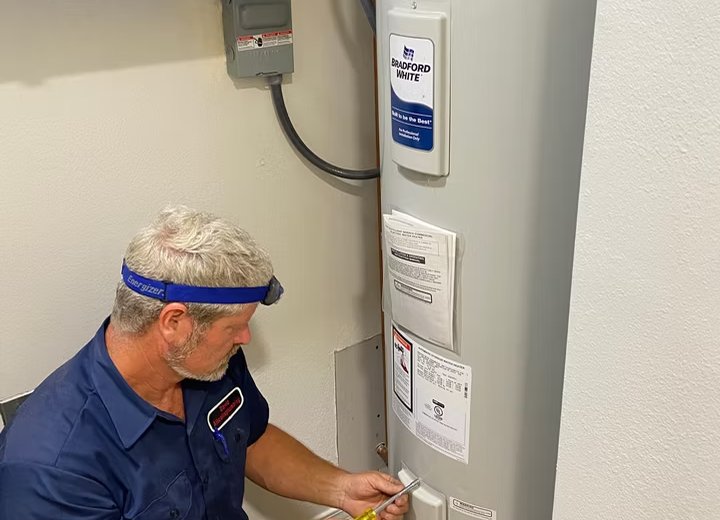 Plumber installing a Bradford White water heater in a garage