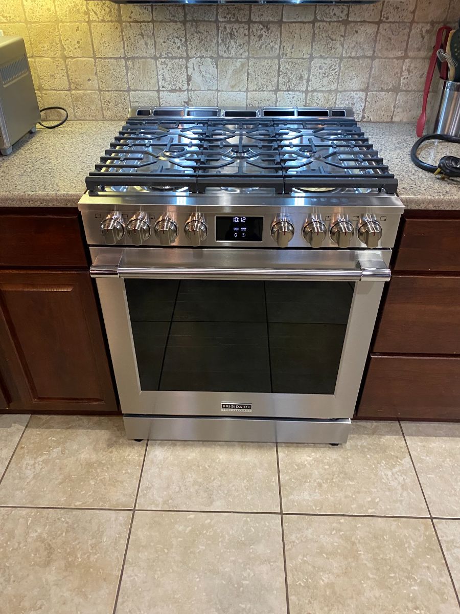 New gas range installed and connected in a kitchen